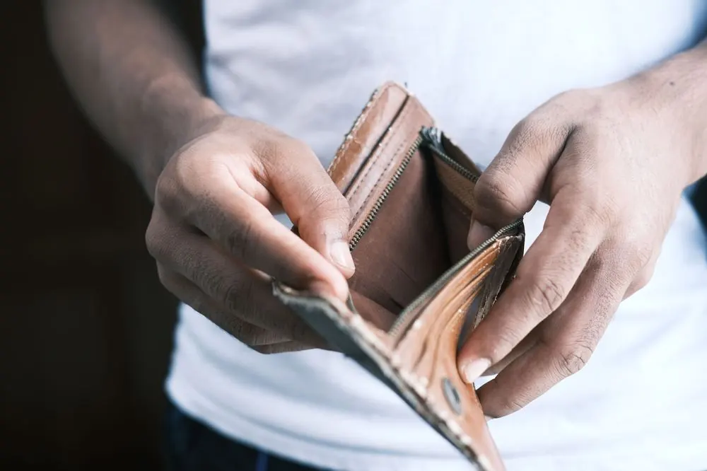 Manos abriendo una cartera vacía