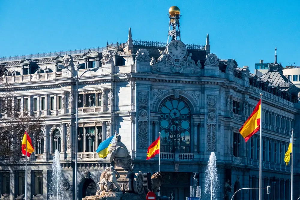 Edificio del Banco de España en Madrid con banderas de España junto a la fuente de Cibeles