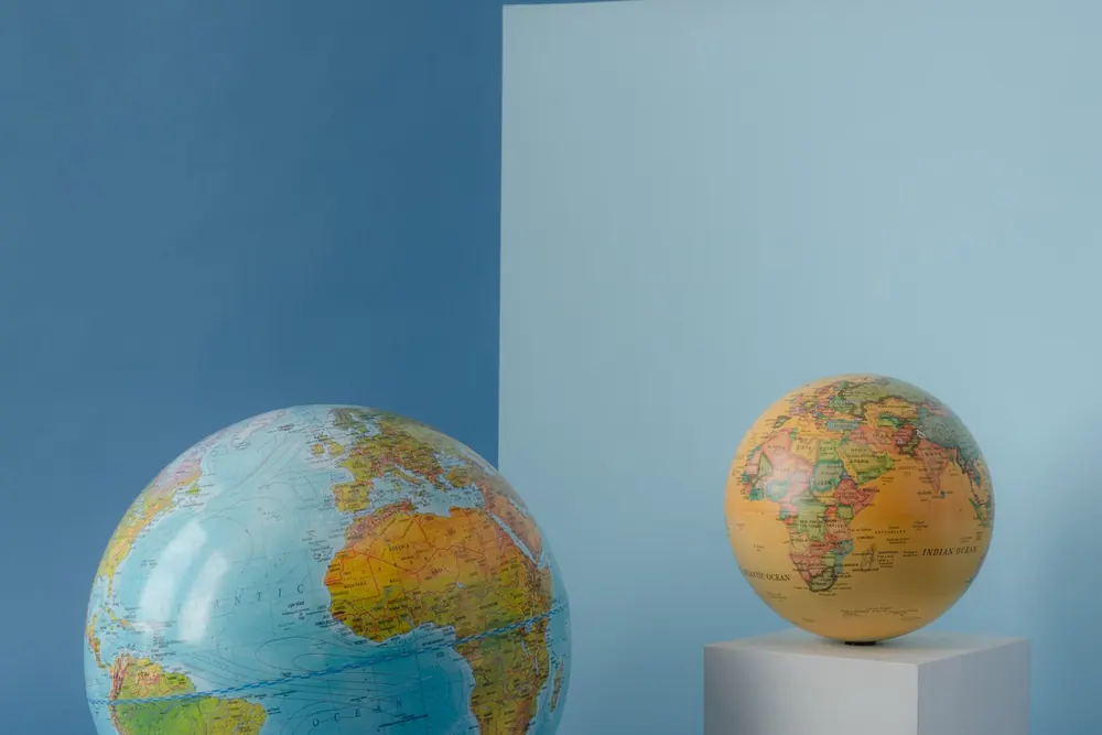 Dos globos terráqueos de distinto tamaño sobre un fondo azul