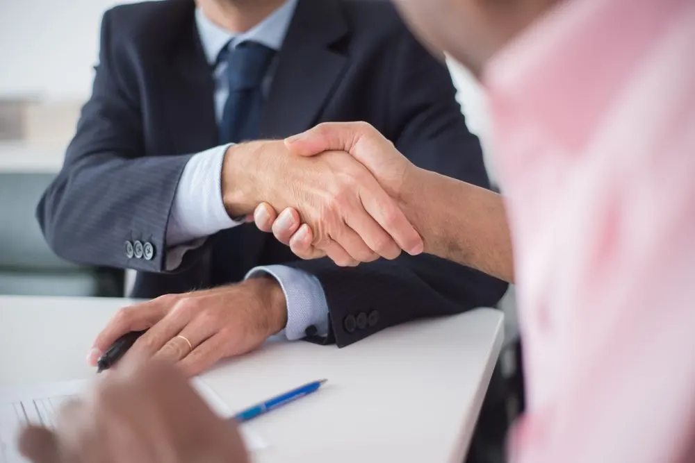 Apretón de manos sobre una mesa de reuniones