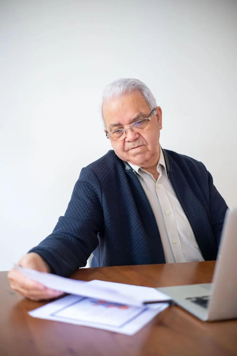 Hombre mayor revisando documentos en su escritorio