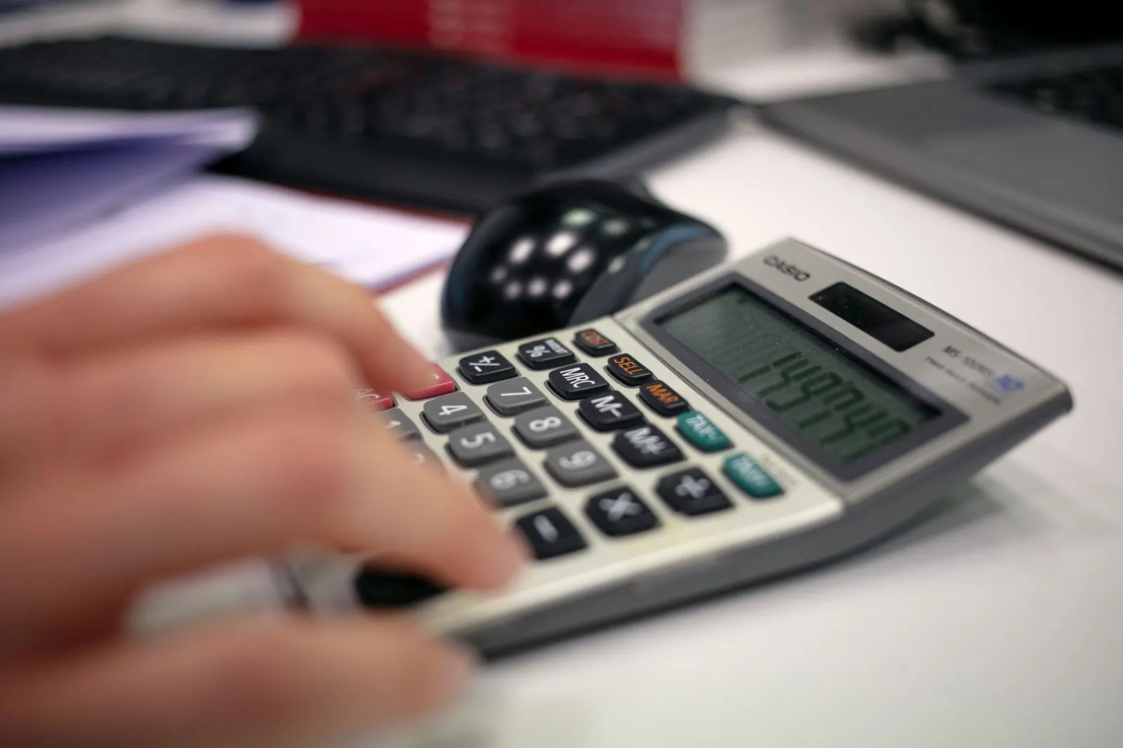 Mano usando una calculadora sobre un escritorio